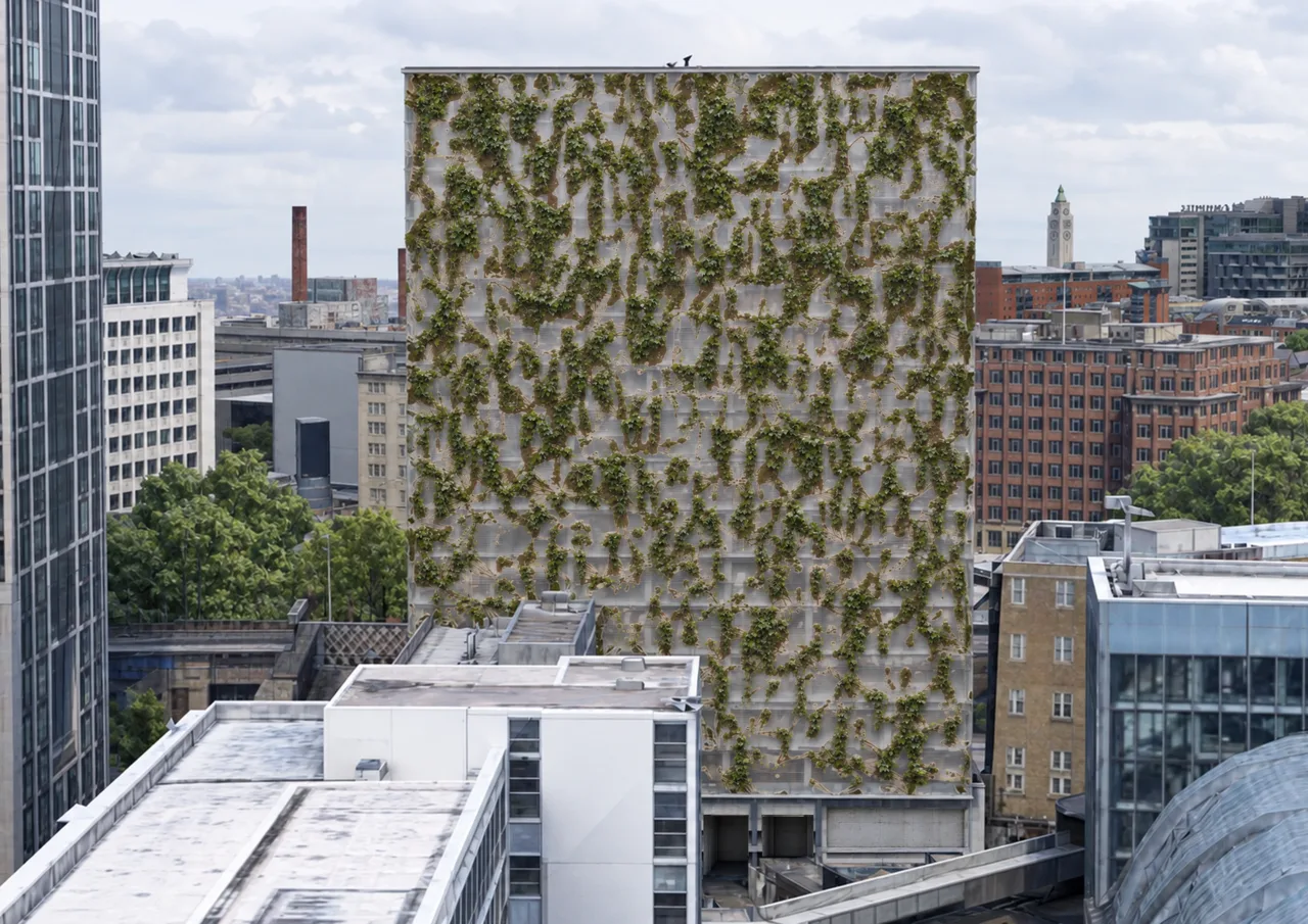 从周边街区观察立面整体。方案效果图。 / The facade seen across the surrounding urban fabric. Proposal rendering.